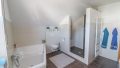 Badezimmer mit stylischer Badewanne und Duschbereich
